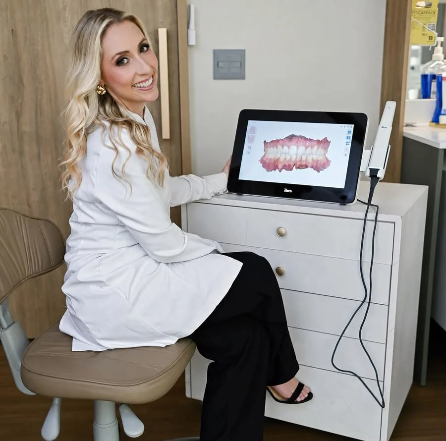 Dra. Karina ao lado do scanner intraoral iTero durante o planejamento digital